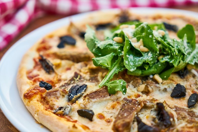 frische Pizza auf einem weißem Teller Pizza auf einem Teller