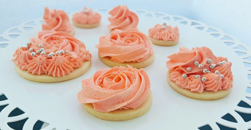 Plätzchen mit Buttercreme mithilfe einer Sterntülle dekoriert. Mehrweg Spritzbeutel werden häufig aus Baumwolle oder Silikokn hergestellt.