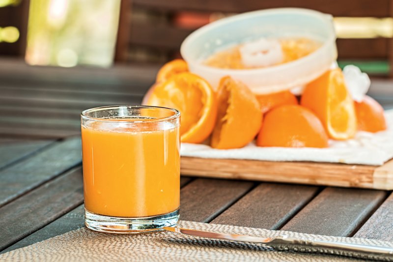 Orangensaft mit Orangen im Hintergrund Orangensaft mit Orangen im Hintergrund