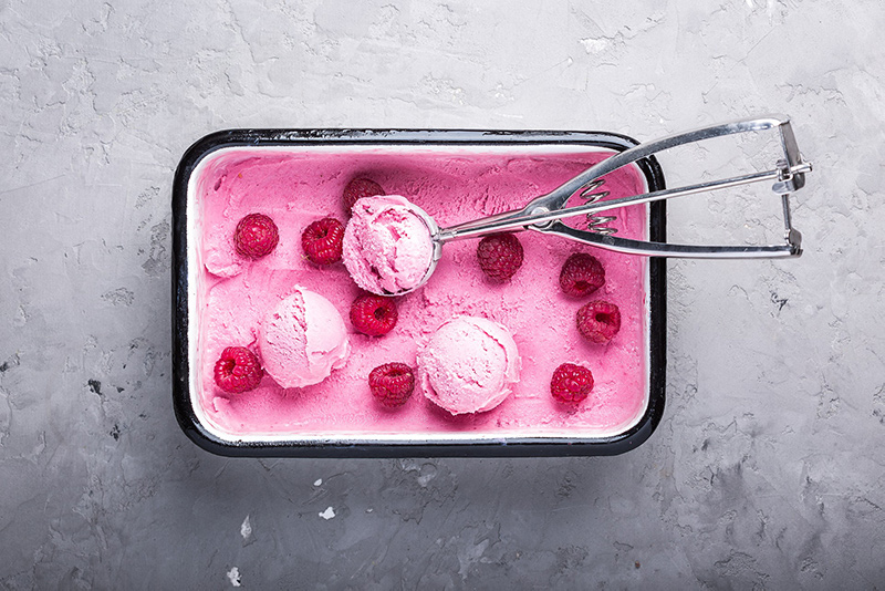 himbeereis mit himbeeren aus der eismaschine mit grauem hintergrund Eismaschine mit Kompressor Speiseeis