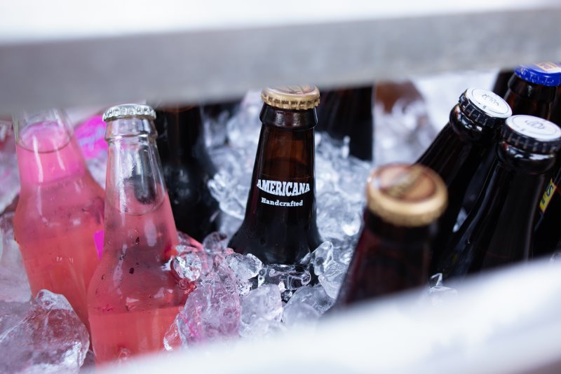 Flaschen in einer leicht geöffneten Kühlbox mit Eiswürfel Kühlbox mit Flaschen und Eiswürfel