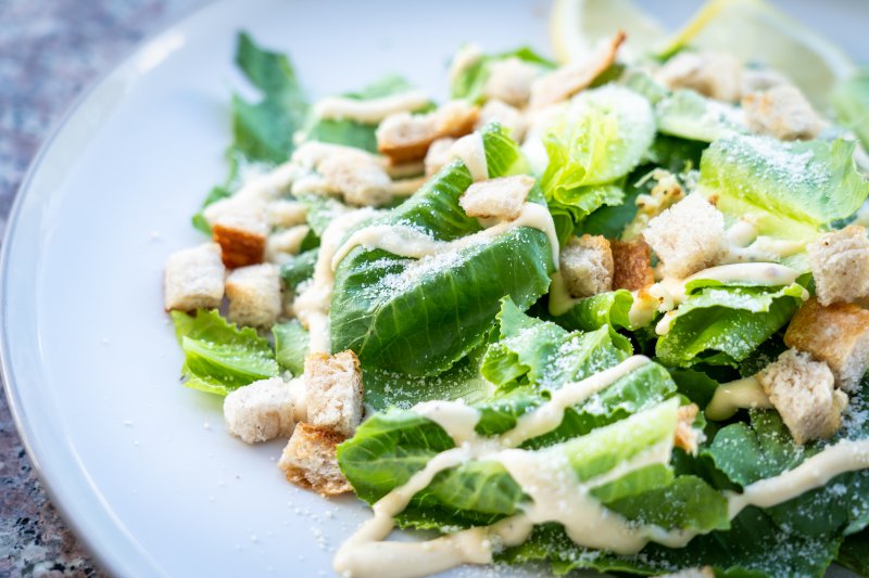 Salat mit Dressing und Croutons auf einem Teller Salat mit Dressing