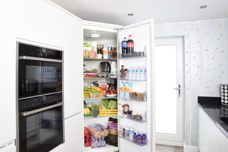 Standkühlschrank offen in weißer Küche Großer Standkühlschrank, der optisch in die Küche integriert wurde.