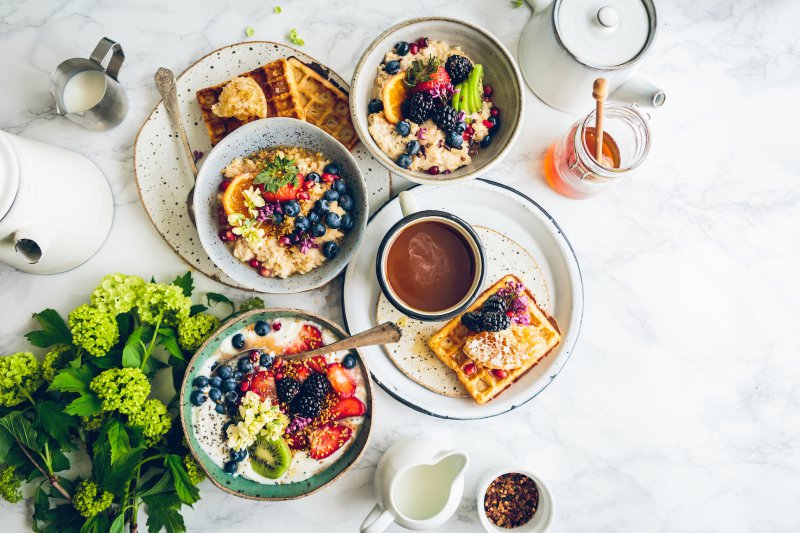 Belgische Waffeln zum Frühstück Belgische Waffeln zum Frühstück neben Haferflocken, Obst und Kaffee