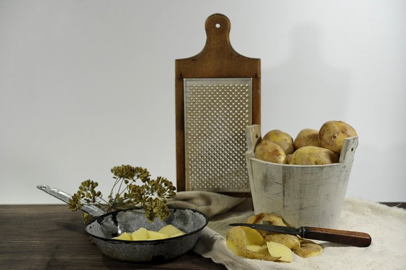 Küchenhobel mit Kartoffeln Küchenhobel zum Zerkleinern von Lebensmitteln