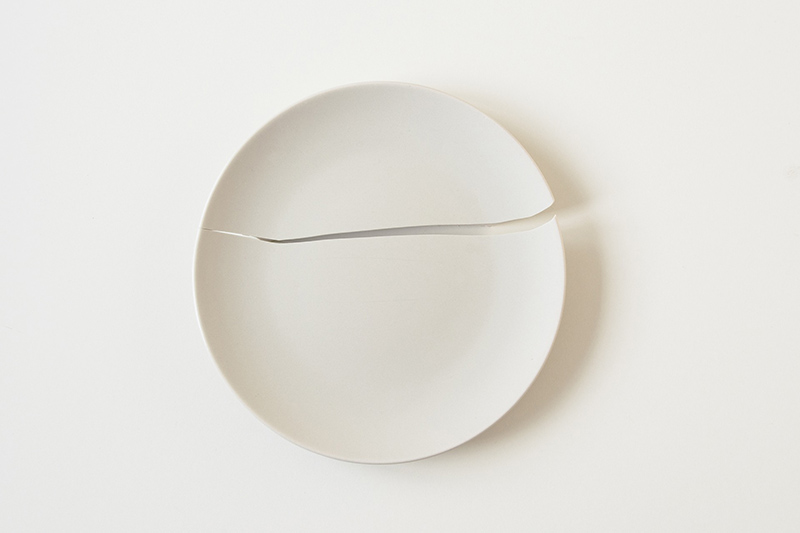 Einen gebrochenen Teller verschönern durch Kintsugi gebrochener weißer Teller Kintsugi