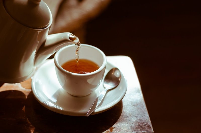 Eine Teekanne mit einer Teetasse Eine Teekanne aus Keramik mit einer Teetasse auf dem Tisch