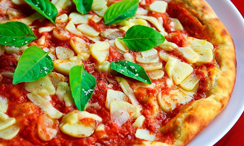 Knoblauchschneider, Knoblauchscheiben auf einer Pizza Knoblauchschneider im Test